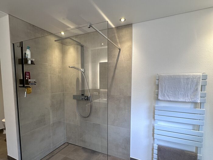 Walk-in-Dusche mit Glaswand, Regenbrause und Handtuchheizkörper